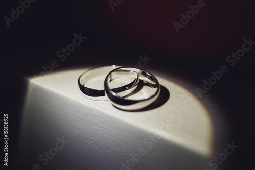 Wedding rings lie in the spot of light