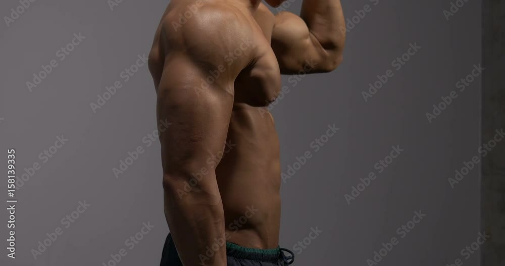 Stockvideon The muscular torso of a fitness model is filmed from ...