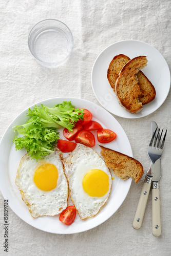 Breakfast - Fried Eggs with tomato, bread, lettuce and glass