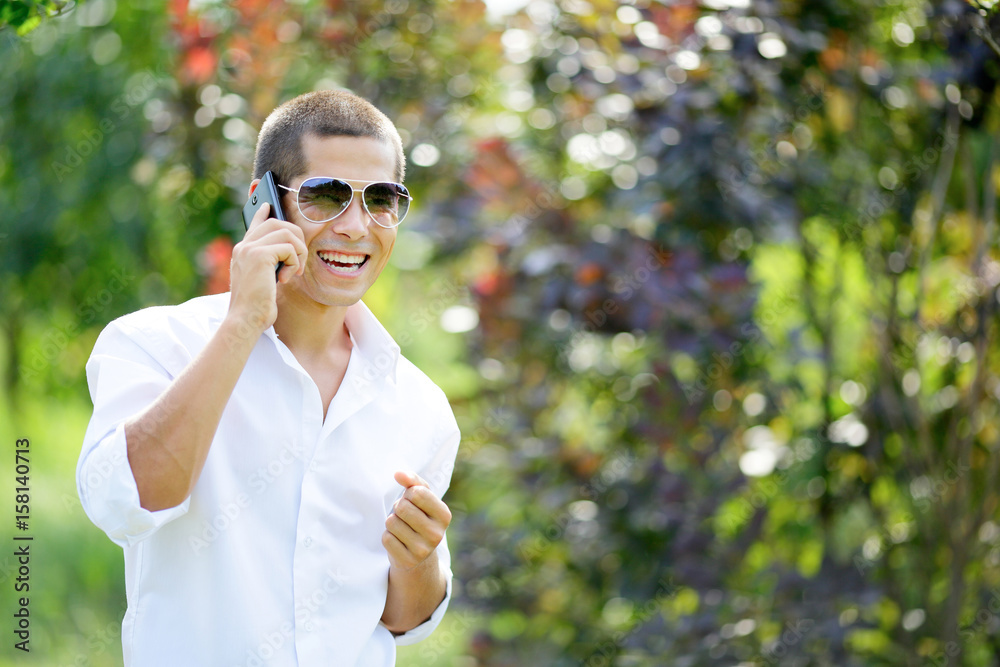 Young laughing man talking on a mobile phone Young laughing man talking on a mobile phone