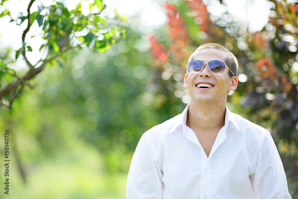 Laughing young man in sunglasses on outdoors Laughing young man in sunglasses on outdoors