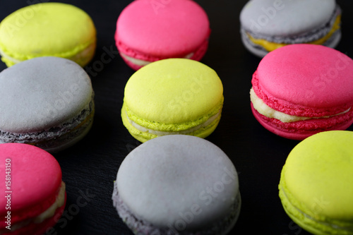 Assorted colorful macaroon on slate background