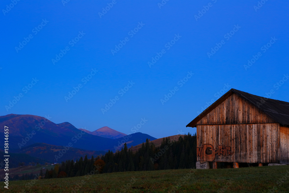 Wooden barn with graffiti in the background morning mountain