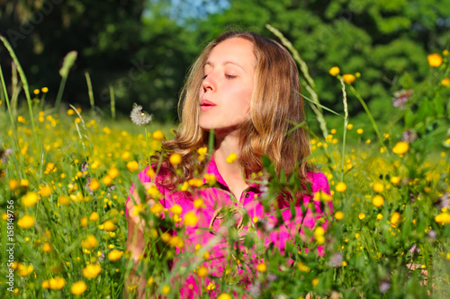 Beautiful woman blows away dandelion