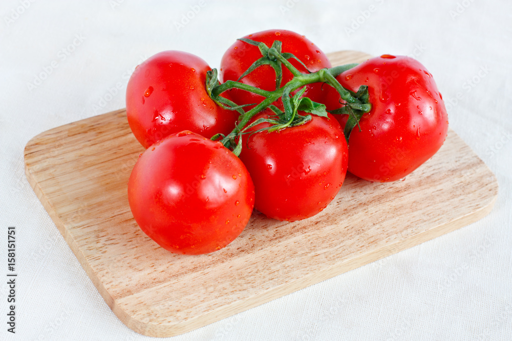 Branch of tomatoes on a cutting board Branch of tomatoes on a cutting board