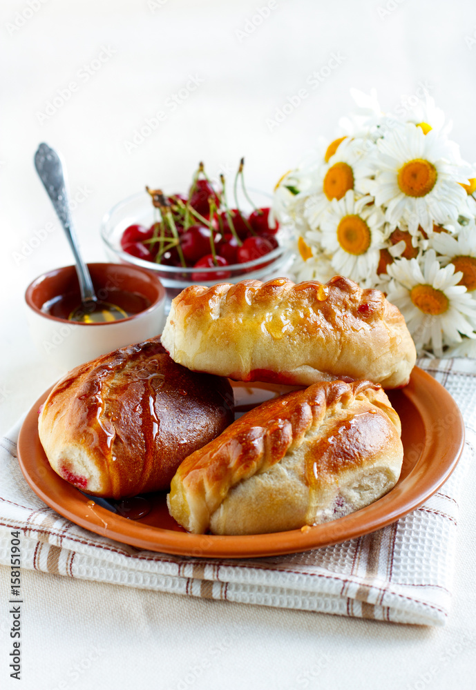 Sweet patties with cherry on a rustic plate soaked in honey Sweet patties with cherry on a rustic plate soaked in honey