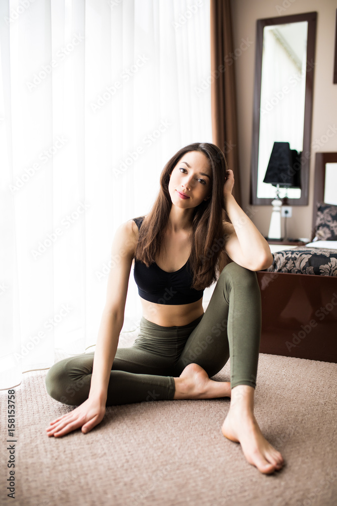 Attractive young woman working out at home, doing yoga exercise on the floor resting after practice Attractive young woman working out at home, doing yoga exercise on the floor resting after practice