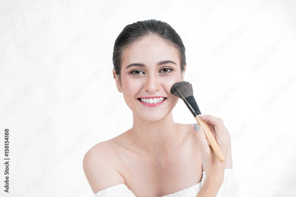 Asian Woman beauty ace Makeup. Portrait Of beautiful Asian young female applying foundation on face with cosmetic brush. Isolated on white background Asian Woman beauty ace Makeup. Portrait Of beautiful Asian young female applying foundation on face with cosmetic brush. Isolated on white background