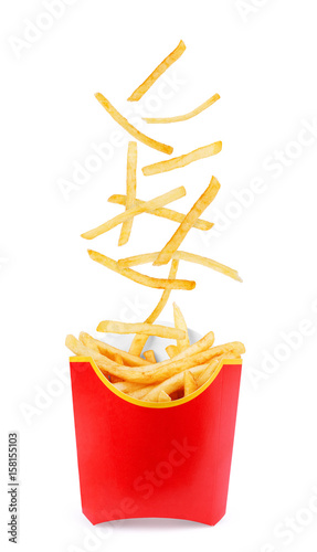 French fries flies into a red cardboard box on a white background photo