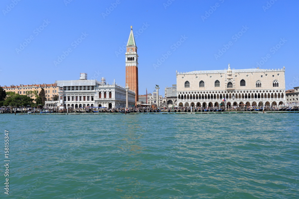 VENICE - APRIL 9, 2017: The view on San Marco Square, Campanile and Doge Palace with tourists near the Doge Palace, on April 9, 2017 in Venice, Italy