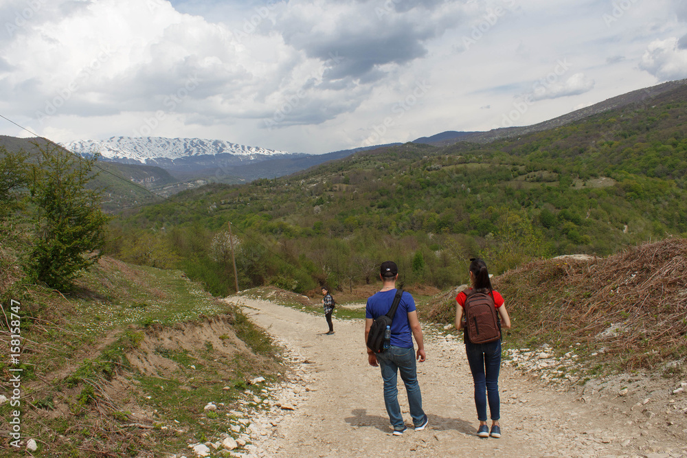Travelers travel on the road in mountains go trekking Countryside, village - mountains, Clouds