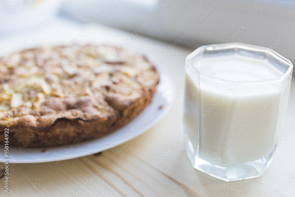 Apple pie on a plate and a glass of milk Apple pie on a plate and a glass of milk
