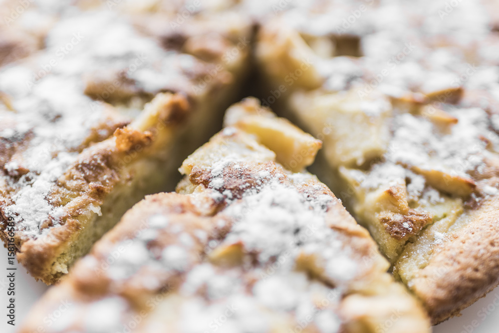 Apple pie and sliced piece of pie in powdered sugar, close-up view Apple pie and sliced piece of pie in powdered sugar, close-up view