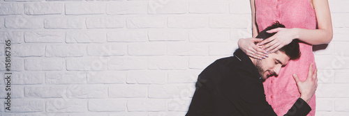 Fotografie Loving man kneeling embracing girlfriend