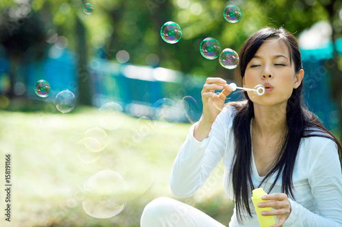 pregnant woman blowing bubbles in the park