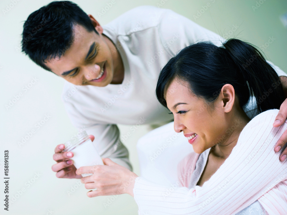 husband and pregnant wife holding a glass of milk husband and pregnant wife holding a glass of milk