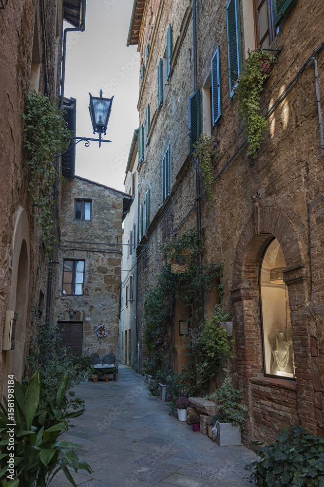 Fototapeta premium Beautiful narrow street in the small magical and old village of Pienza, Val D'Orcia Tuscany - Italy