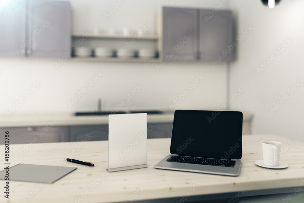 Blank laptop in blurry kitchen Blank laptop in blurry kitchen