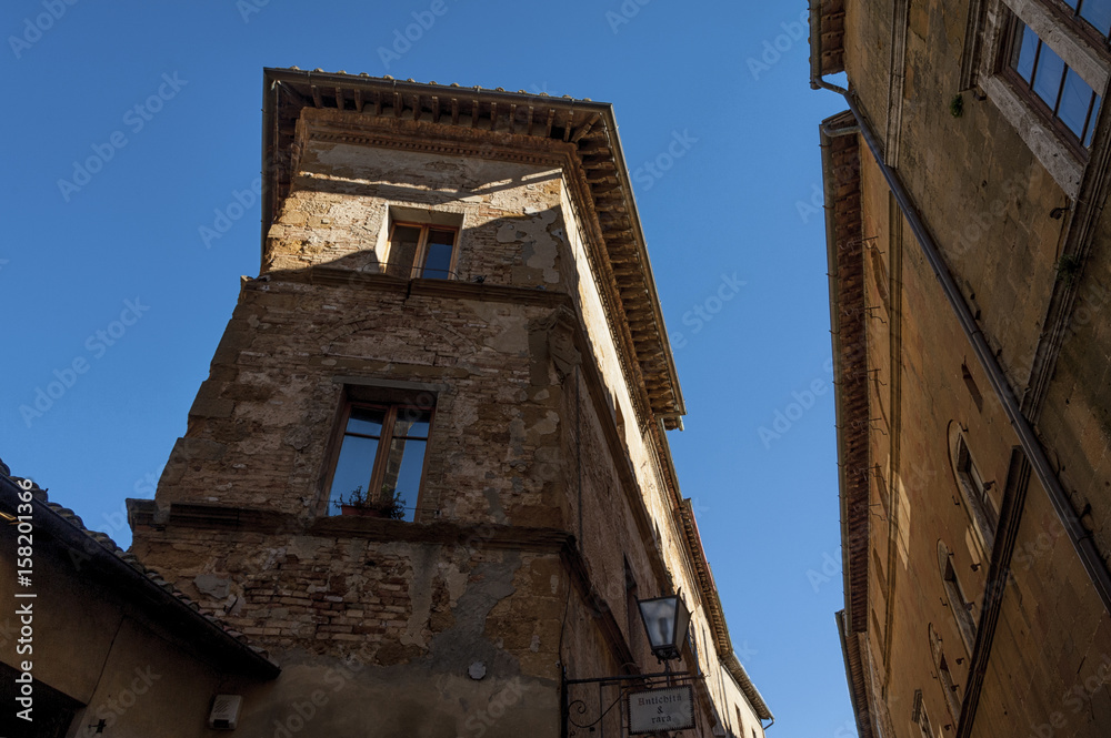  Beautiful narrow street in the small magical and old village of Pienza, Val D'Orcia Tuscany - Italy