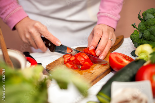 Woman cutting tomato on slices