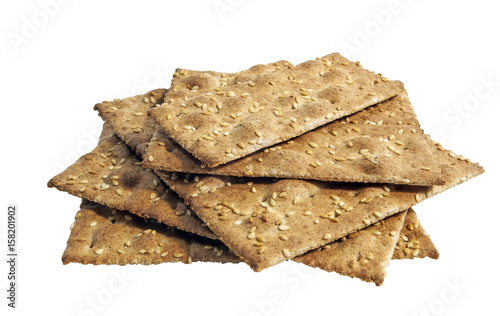 Stack of wheat crackers topped with sesame seeds. Isolated.