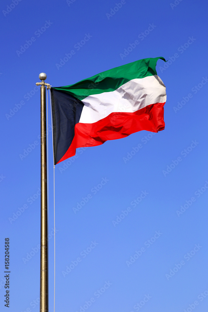 Waving National Flag Of Kuwait On A Blue Daytime Sky Waving National Flag Of Kuwait On A Blue Daytime Sky