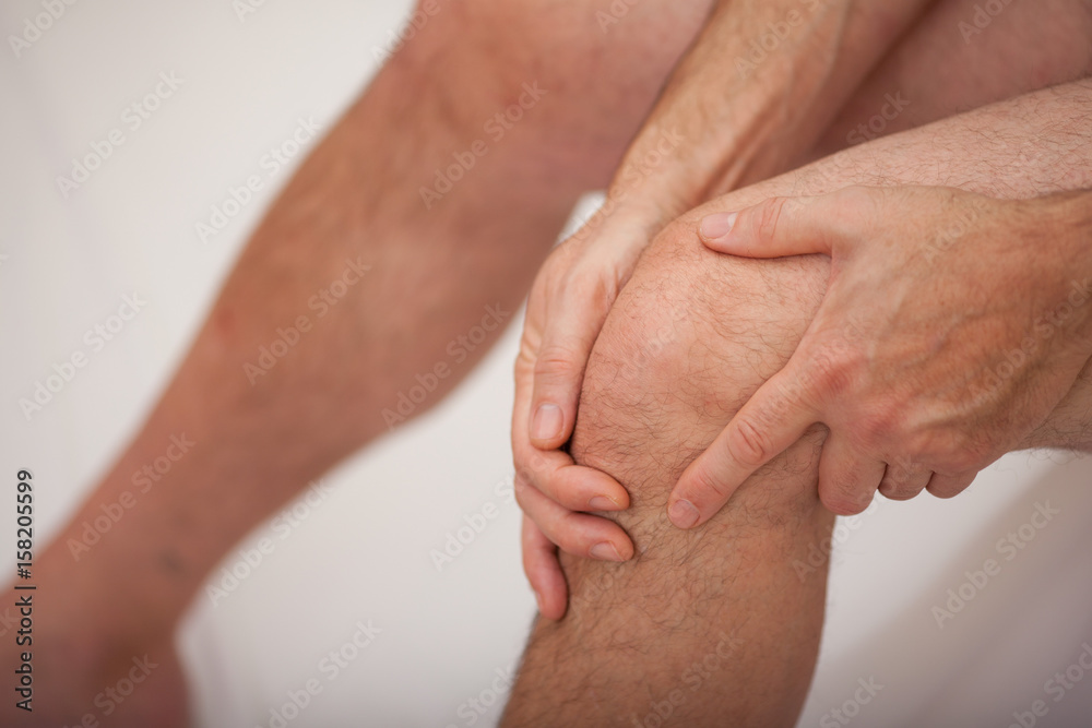 Man holding his knee Man holding his knee