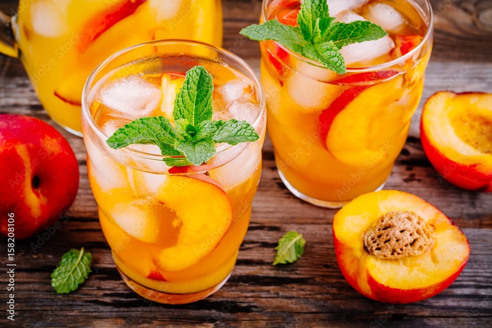 Summer cold drinks: homemade peach sangria with ice cubes, and mint in glasses
