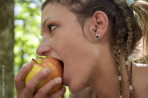 Healthy young woman biting into an apple photo