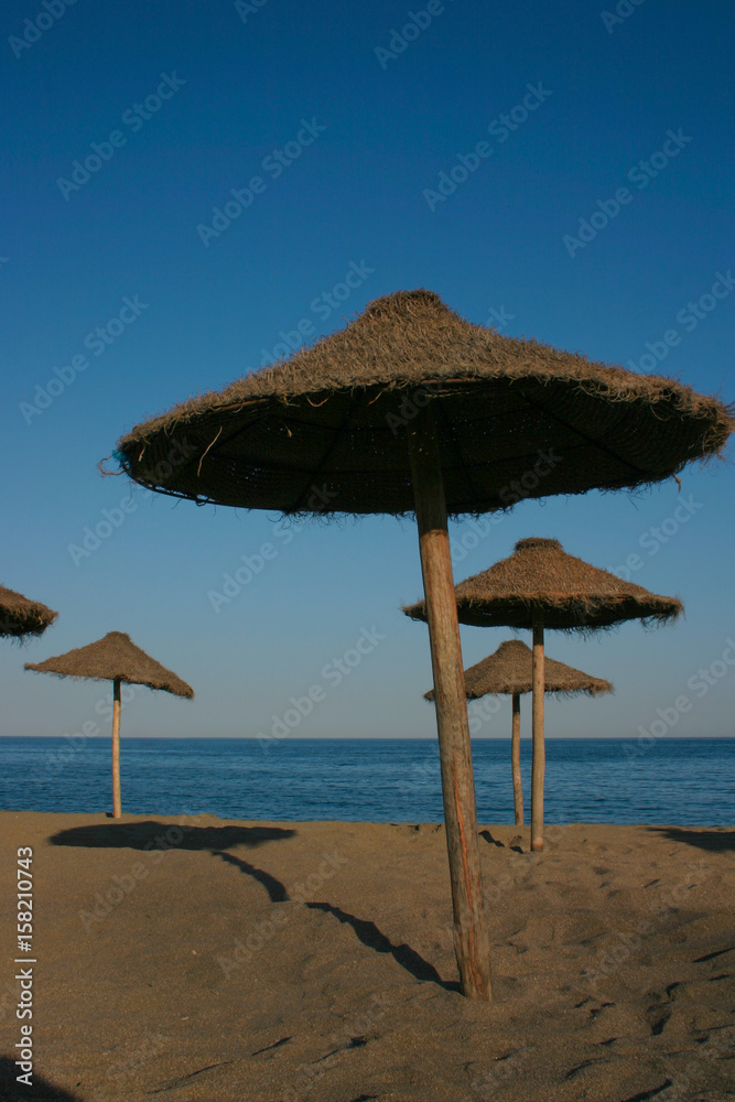 Straw umbrellas on a beautiful tropical beach Straw umbrellas on a beautiful tropical beach