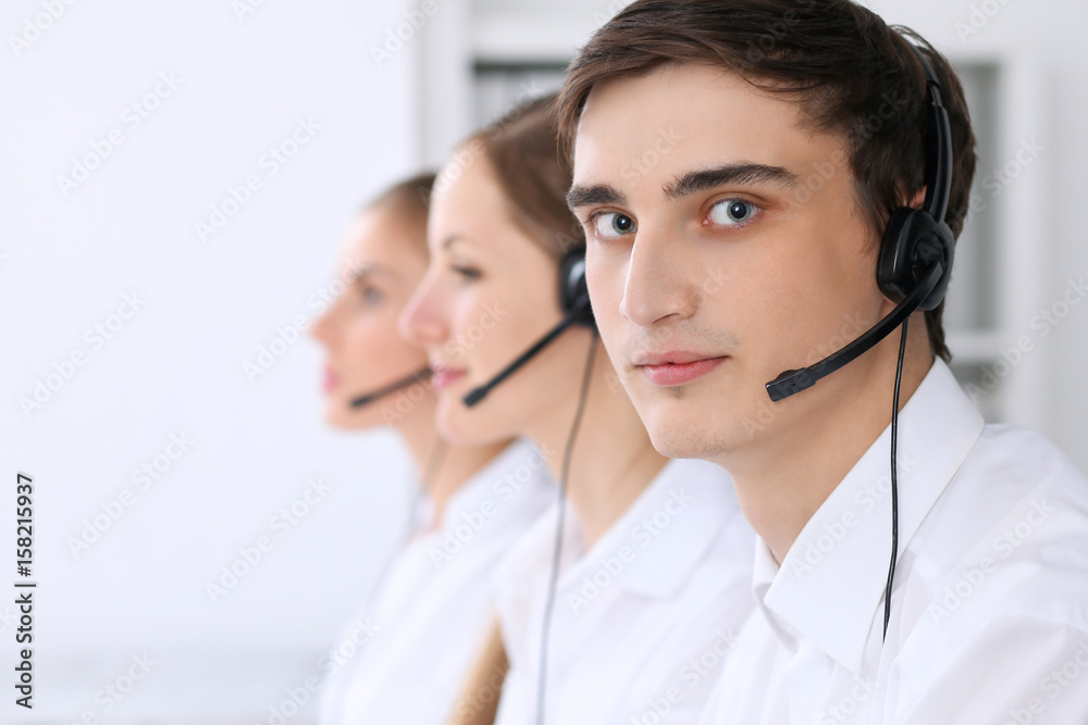 Call center. Focus on a man in headset Call center. Focus on a man in headset