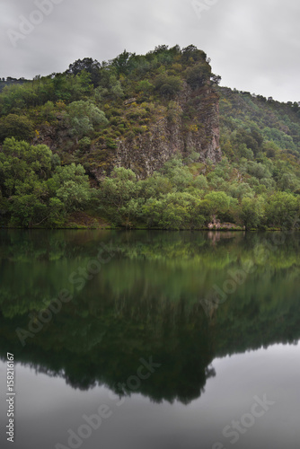 Scenic landscape of reflections and ruins in a tranquil lake on a cloudy day  La Rioja  Spain.
