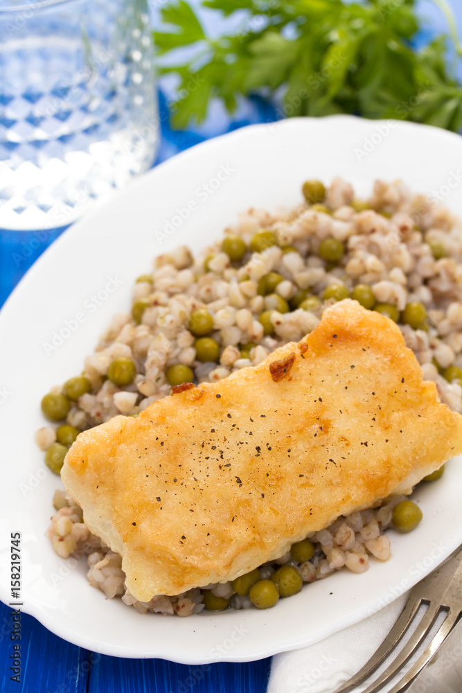 fried fish with boiled buckwheat and peas in white dish fried fish with boiled buckwheat and peas in white dish