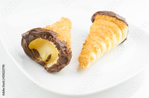 delicious sicilian cannolo cannellino sweet with pastry hazelnut chocolate and pastry cream, italian puff-pastry on white background, nutrition and diet