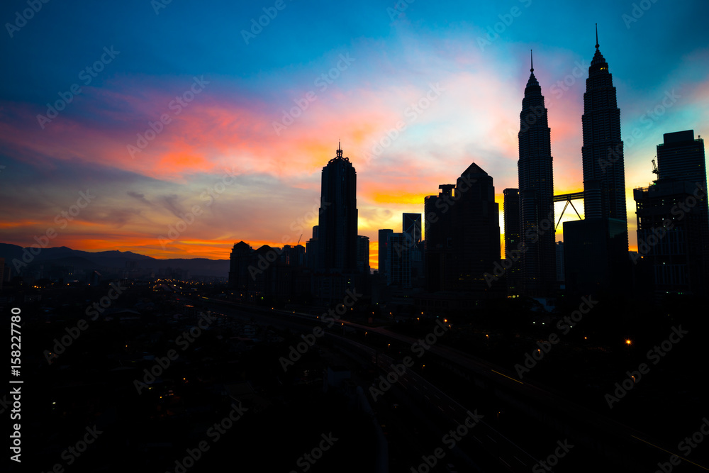 A cloudy sunrise in Kuala Lumpur, the capital of Malaysia. Its modern skyline is dominated by the 451m tall KLCC, a pair of glass and steel clad skyscrapers. A cloudy sunrise in Kuala Lumpur, the capital of Malaysia. Its modern skyline is dominated by the 451m tall KLCC, a pair of glass and steel clad skyscrapers.