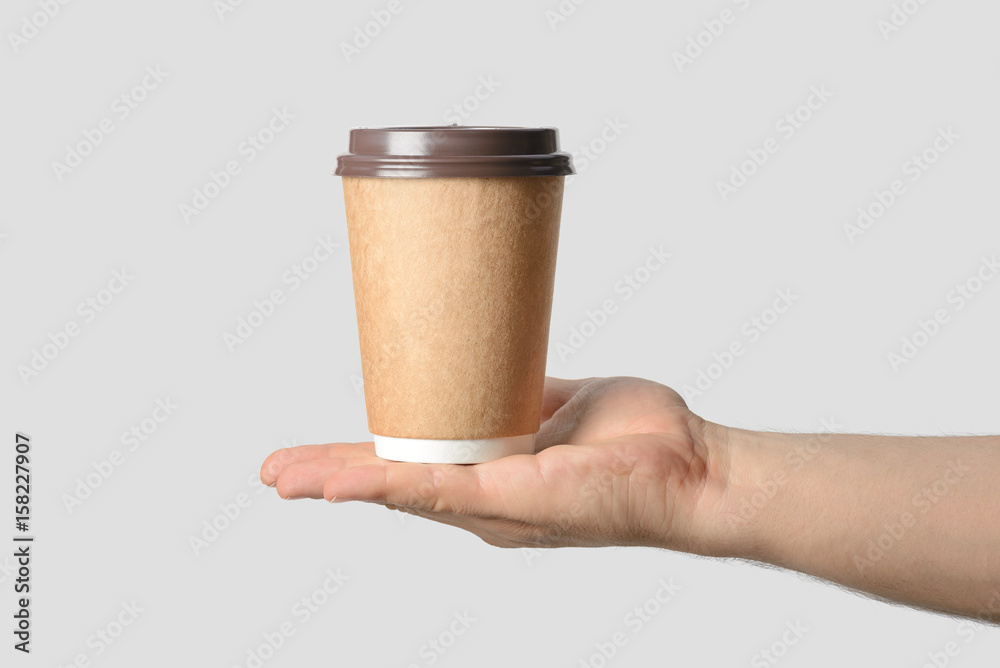 Mockup of male hand holding a Coffee paper cup isolated on light grey background. Mockup of male hand holding a Coffee paper cup isolated on light grey background.