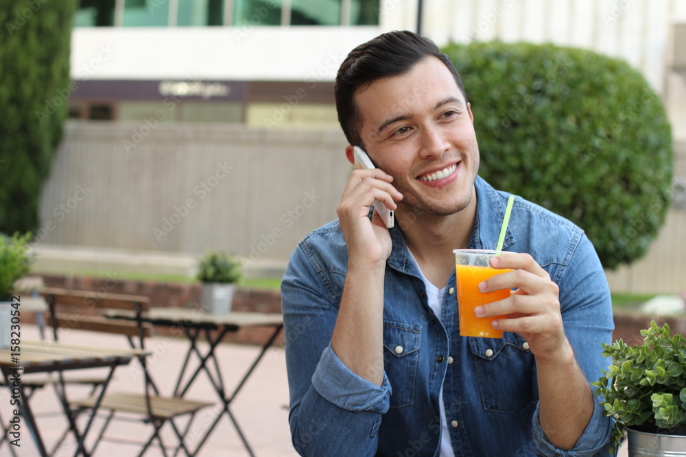 Fototapeta premium Man calling by phone while enjoying a nice drink outside