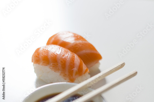 Sushi. Salmon niguiris on white background with chopsticks and soy