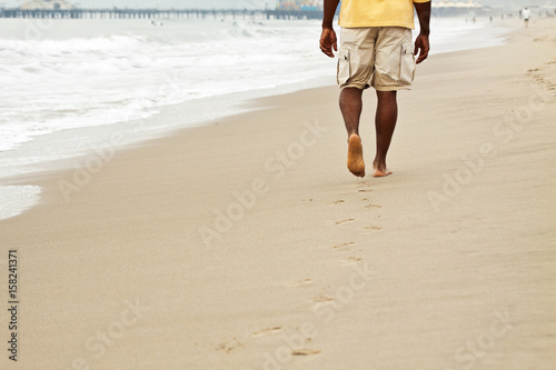 African American man walking on the beach. © digitalskillet1