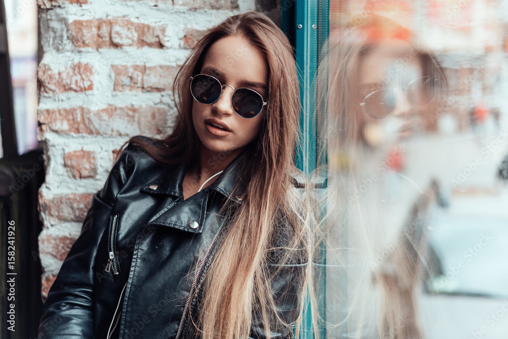 Beautiful girl in sunglasses posing on camera