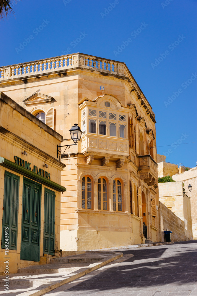 Traditional maltese townhouse built of limestone with wooden balconies in Rabat (Victoria), Gozo, Malta