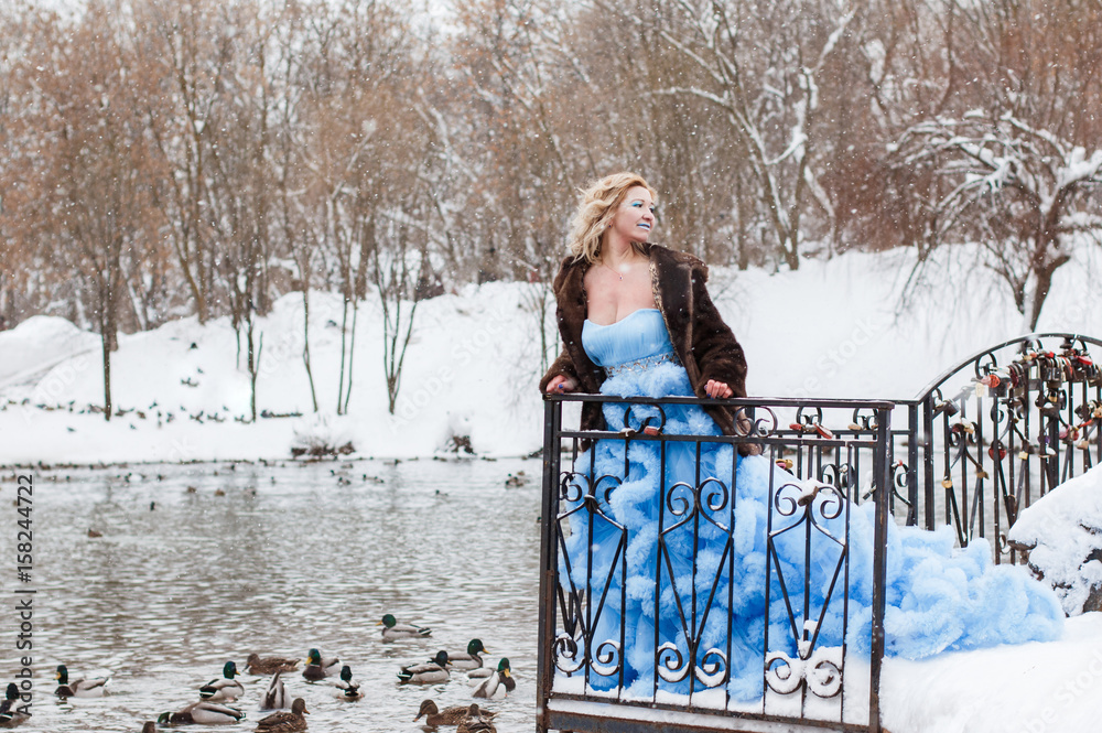Woman in a beautiful blue dress in a winter