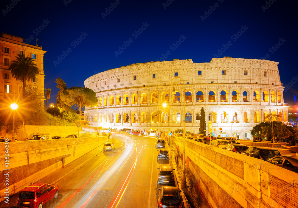 view of Colosseum illuminated at nighwith traffic lightst in Rome, Italy, retro toned