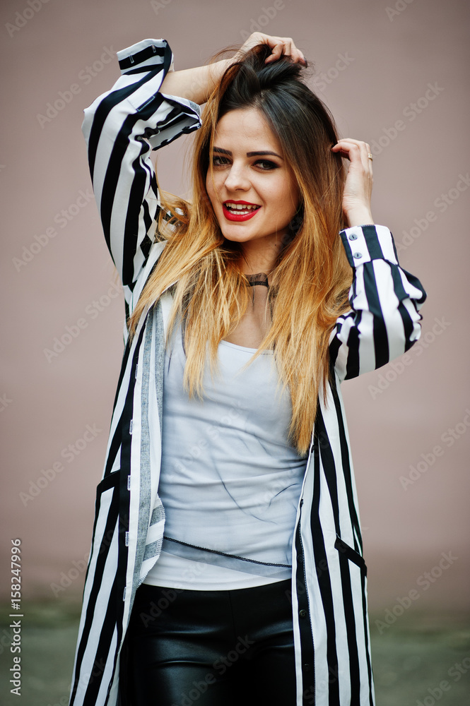 Close up portrait of fashionable woman look with black and white striped suit jacket, hands on hair. Emotional fashion girl.