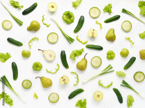 Vegetables and fruits on a white background. Pattern of vegetables and fruits. Food background. Collage of food. Top view. Composition of cucumber, pepper, lettuce leaves, pear, onion, green radish.