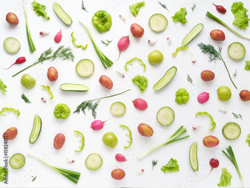 Vegetables and fruits on a white background. Pattern of vegetables and fruits. Abstract food background.  Top view. Food collage of potato, green radish, pepper, lettuce, green apples, cucumber, onion