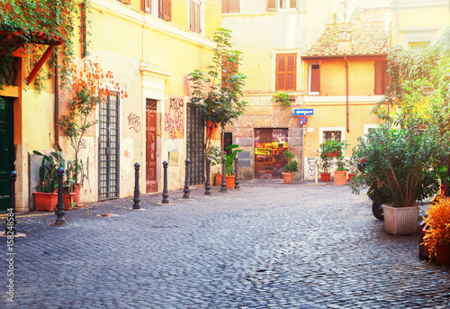 typical italian street in Trastevere with green plants, Rome, Italy, retro toned