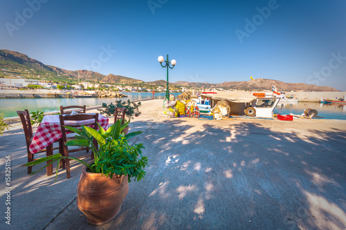 Chairs with tables in typical Greek tavern at the harbor of Makri Gialos, Crete, Greece. photo