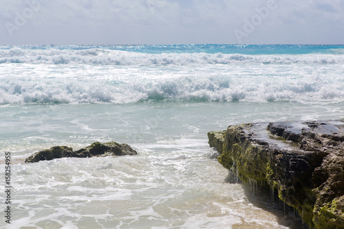 Fototapeta Brzeg morza karaibskiego. Plusk wody i spływające z klifów. Słoneczny letni dzień.