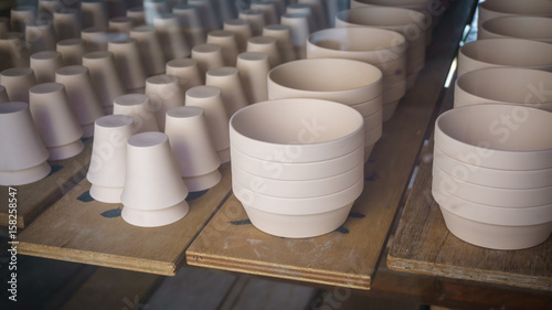 Pottery drying and sitting in a warehouse waiting to be completed.
